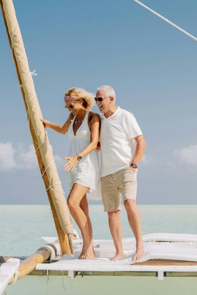 A couple relaxing on sun loungers at a private luxury hotel pool area in Zanzibar.