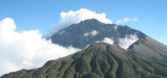Mount Meru in Arusha National Park Tanzania showing scenic volcanic mountain landscape with forest and clouds